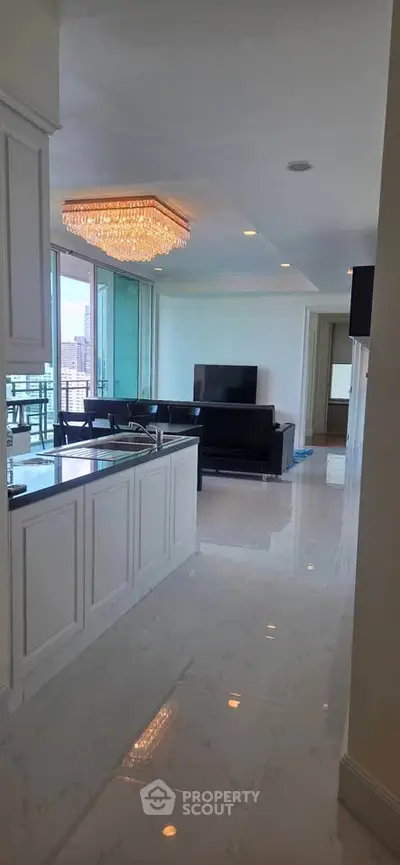 Luxurious open-layout living room with modern kitchen and stunning chandelier