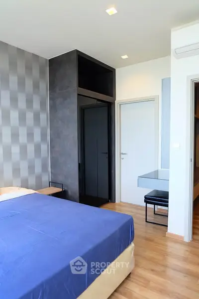 Modern bedroom with stylish decor and hardwood flooring