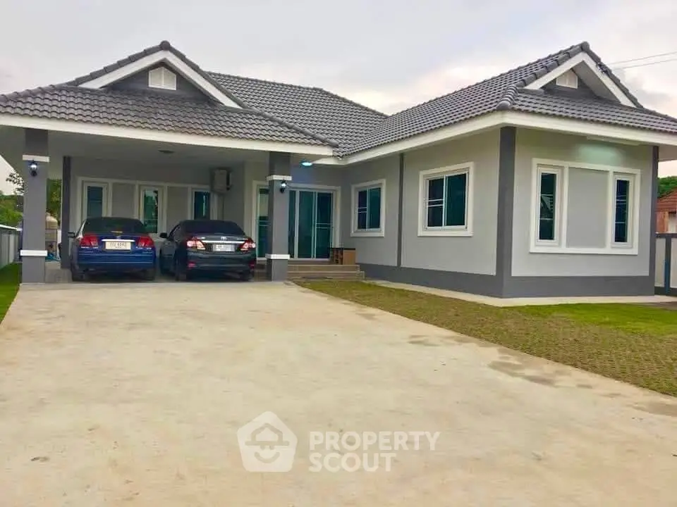 Charming single-story house with spacious driveway and modern exterior design.