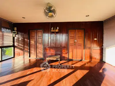 Spacious wooden interior with natural light and elegant paneling, perfect for a serene living space.