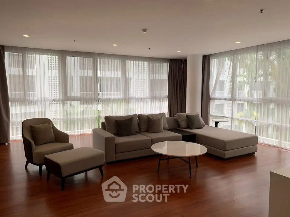 Spacious modern living room with large windows and elegant furniture