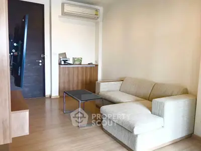 Modern living room with sleek furniture and wall-mounted TV in a cozy apartment.