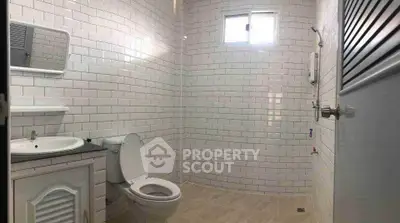 Spacious bathroom with modern white subway tiles and natural light.