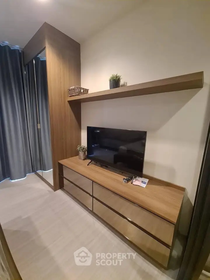 Modern living room with sleek wooden furniture and flat-screen TV, perfect for cozy relaxation.