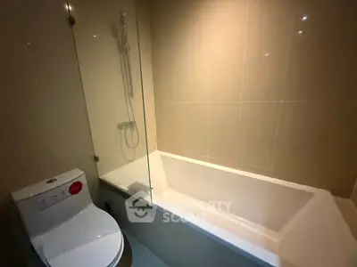 Modern bathroom with sleek bathtub and shower in contemporary apartment.