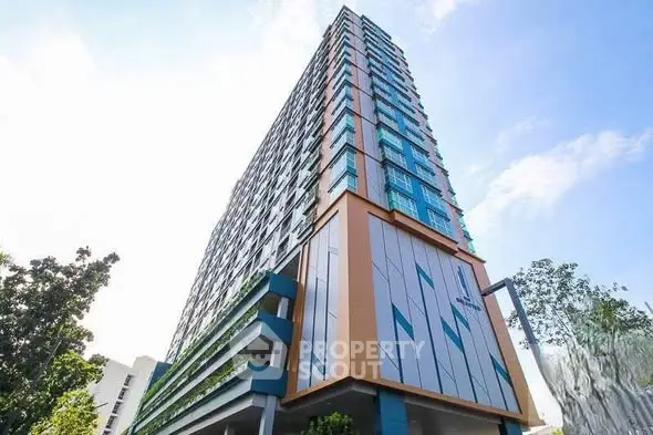Modern high-rise building with sleek architectural design and lush greenery.