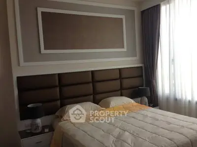 Elegant bedroom with plush headboard and large window for natural light