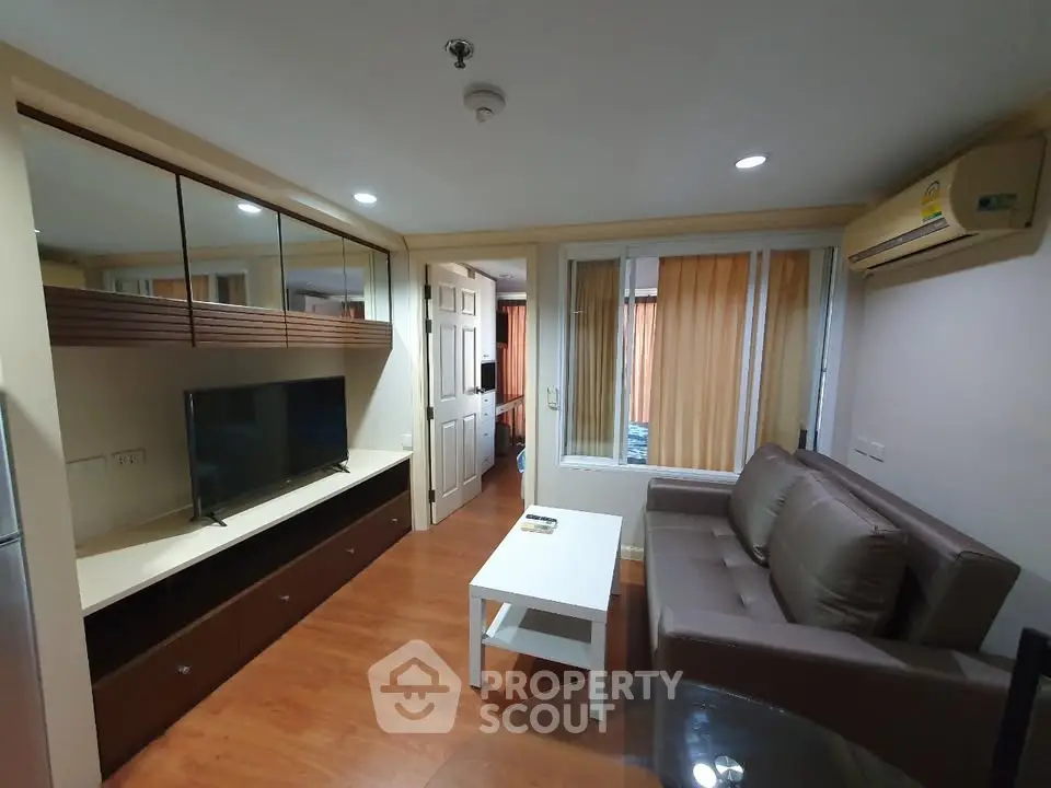 Modern living room with sleek furniture and wooden flooring in a cozy apartment.