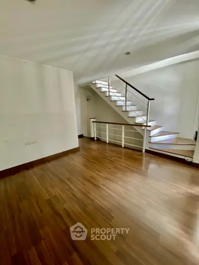 Spacious interior with elegant wooden flooring and modern staircase