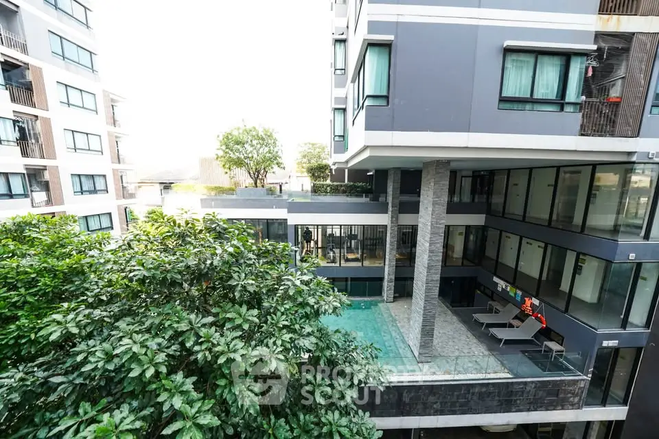 Modern apartment building with pool and lush greenery view