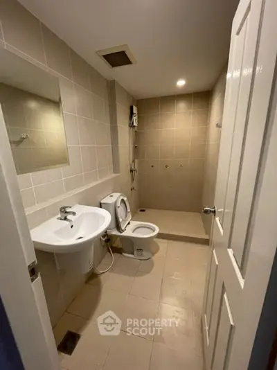 Spacious bathroom with modern fixtures and neutral tiles, perfect for relaxation and comfort.