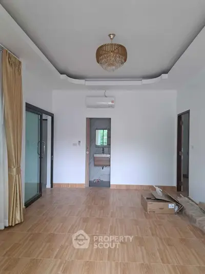 Spacious living room with elegant chandelier and sliding glass doors