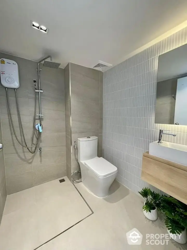 Modern bathroom with sleek fixtures and minimalist design, featuring a spacious shower and elegant vanity.