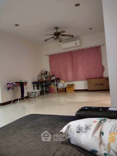 Spacious living room with ceiling fan and air conditioning, ideal for comfortable living.