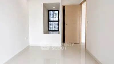 Spacious modern room with large window and glossy tiled floor in a high-rise apartment.