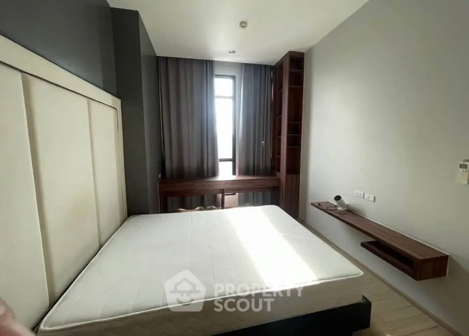 Modern bedroom with large window and stylish wooden furniture