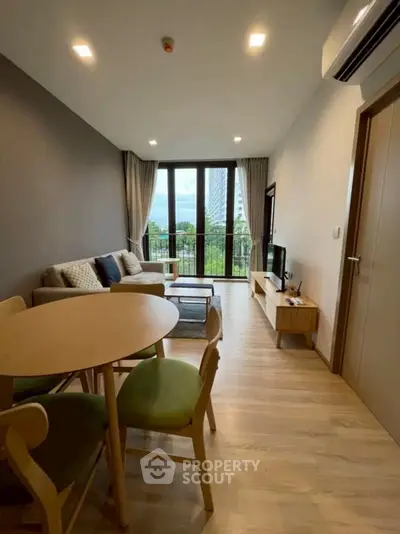 Modern living room with balcony view, stylish furniture, and natural light.