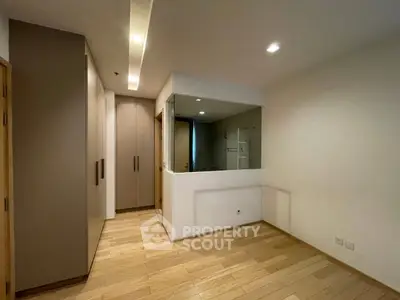 Spacious modern bedroom with wooden flooring and built-in wardrobe