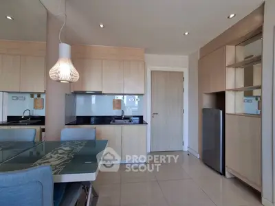 Modern kitchen with sleek cabinetry and dining area in stylish apartment