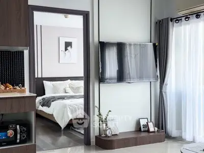 Modern living room with wall-mounted TV and view into cozy bedroom