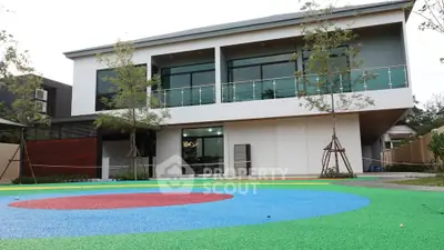 Modern two-story house with colorful circular driveway and balcony