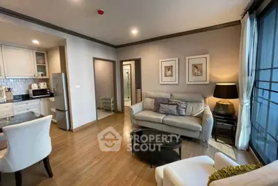 Modern living room with open kitchen, stylish decor, and cozy seating area in a contemporary apartment.