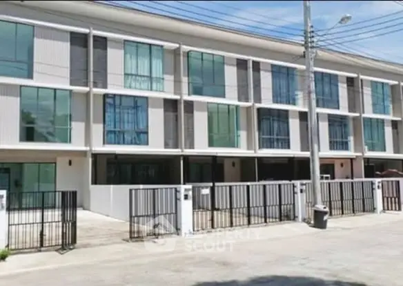 Modern townhouse exterior with large windows and gated entrance