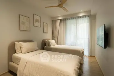 Modern bedroom with twin beds, stylish decor, and natural light from large window.
