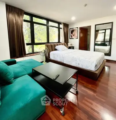 Spacious bedroom with large windows and elegant wooden flooring