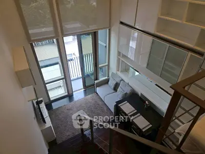 Modern loft-style living room with high ceilings and large windows