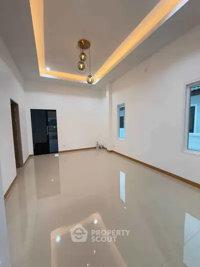 Spacious modern living room with elegant ceiling lights and glossy tiled flooring.