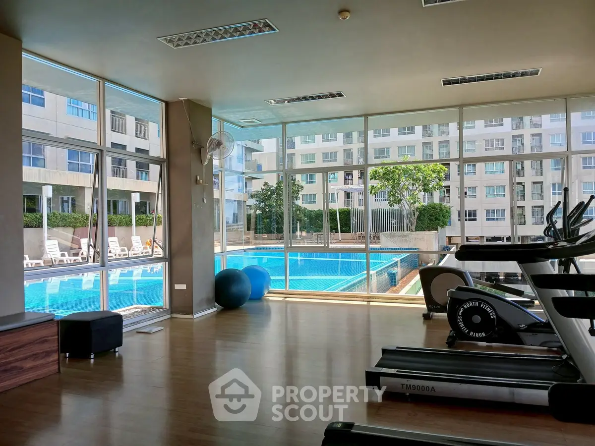 Modern gym with pool view in luxury apartment complex