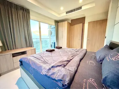 Modern bedroom with large window and stylish decor in a luxury apartment.