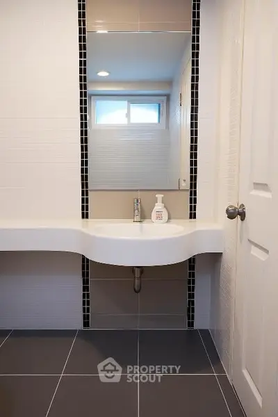 Modern bathroom with sleek sink and stylish black tile accents