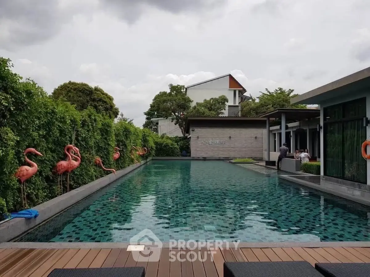 Luxurious outdoor pool area with stylish flamingo decor and modern architecture, perfect for relaxation and leisure.