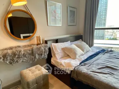 Cozy bedroom with modern decor and city view, featuring a stylish mirror and plush bedding.