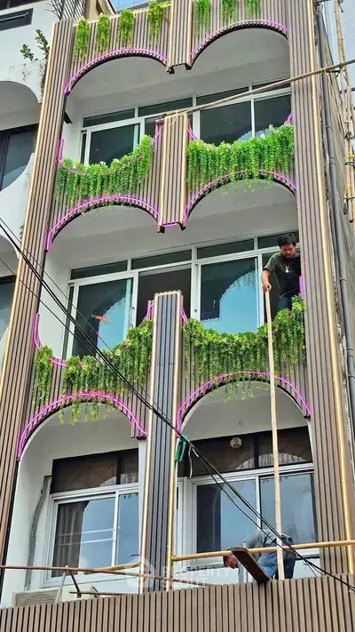 Modern building facade with unique balcony design and lush greenery