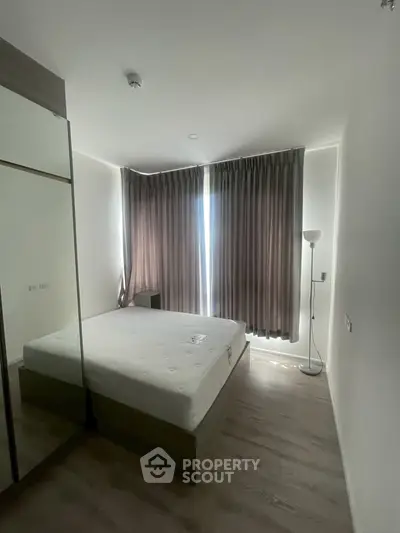 Modern bedroom with large windows and stylish curtains in a contemporary apartment.