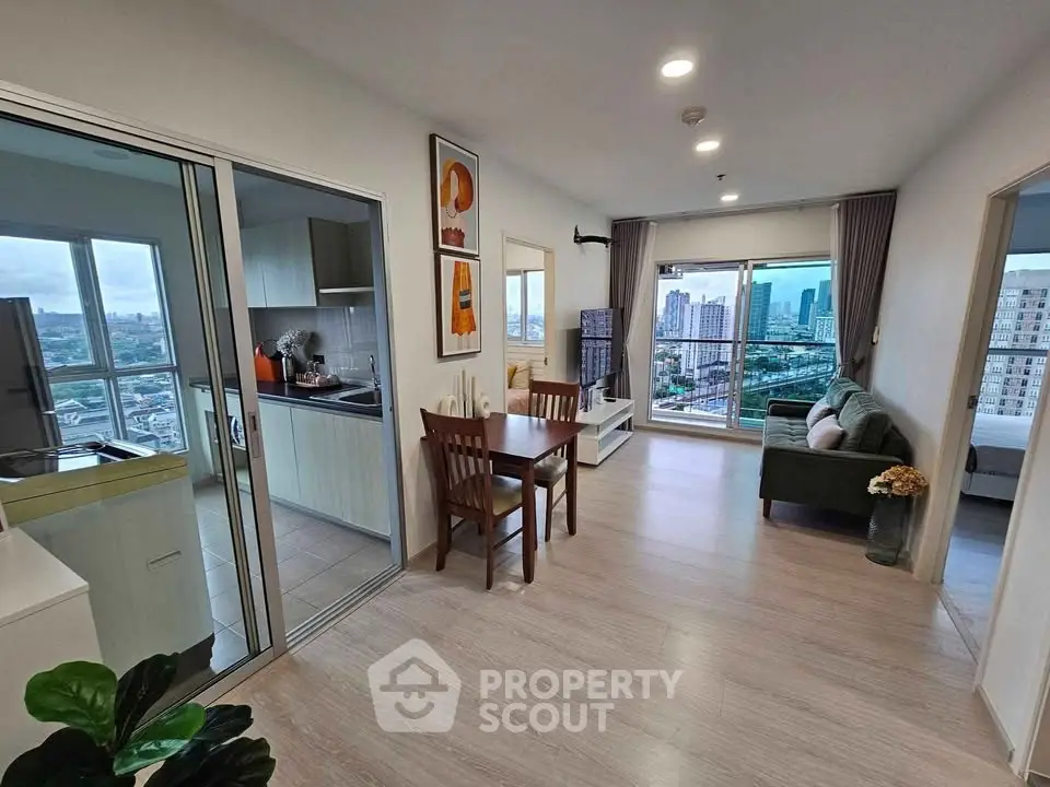 Modern open-plan living room with city view, featuring stylish decor and natural light.