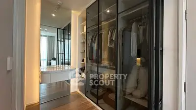 Spacious walk-in closet with sleek glass doors and ample storage space.
