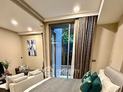 Cozy bedroom with modern decor and large window overlooking a small courtyard.