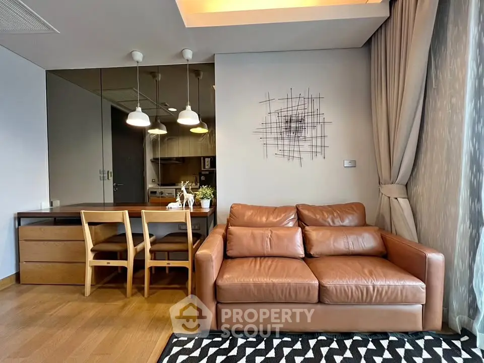 Modern living room with leather sofa and dining area, featuring stylish lighting and wooden flooring.