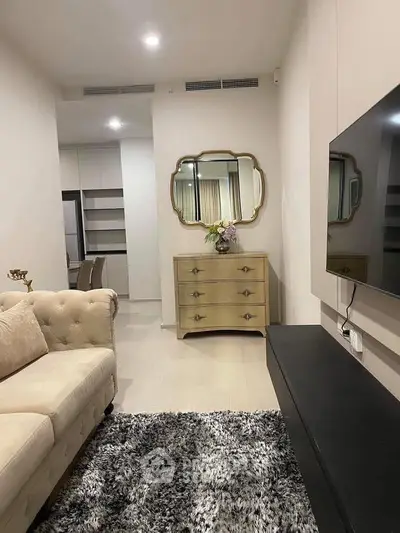Elegant living room with plush sofa, stylish mirror, and modern decor for a cozy ambiance.