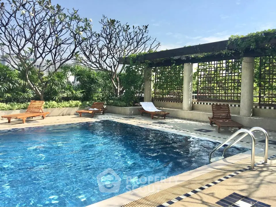 Luxurious rooftop pool with lush greenery and sun loungers, perfect for relaxation and leisure.