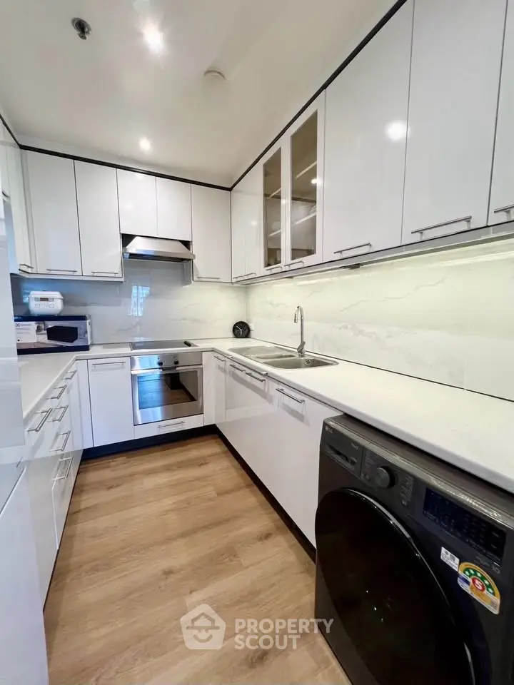 Modern kitchen with sleek white cabinets and integrated appliances