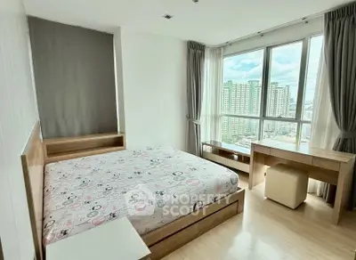 Spacious bedroom with large windows offering stunning city views in modern apartment.