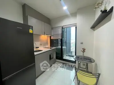 Modern kitchen with sleek appliances and balcony view in urban apartment