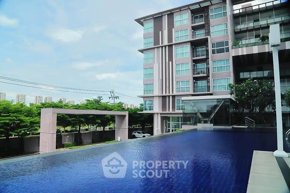 Luxurious modern apartment building with stunning pool and city view, perfect for urban living.