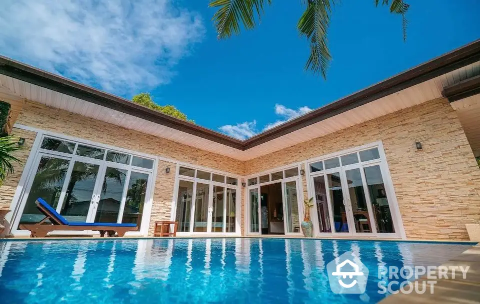 Luxurious villa with private pool and modern architecture under clear blue sky.