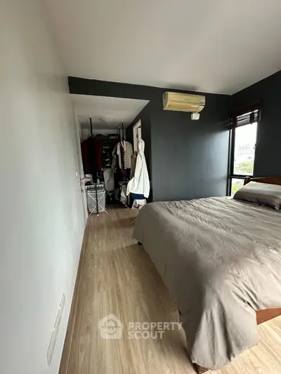 Modern bedroom with sleek design and natural light, featuring a cozy bed and stylish wardrobe.